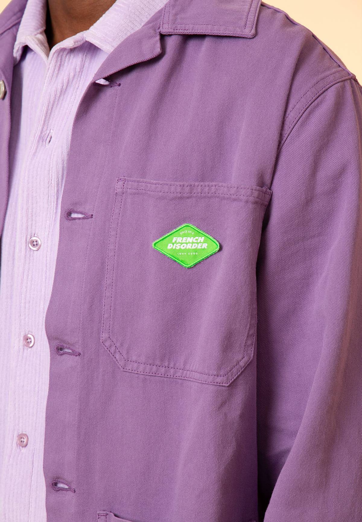 Détail de la poche poitrine avec patch French Disorder vert sur la veste EDEN Purple